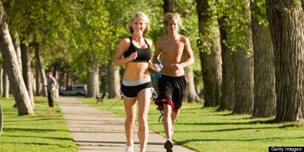 Young couple running outside in park