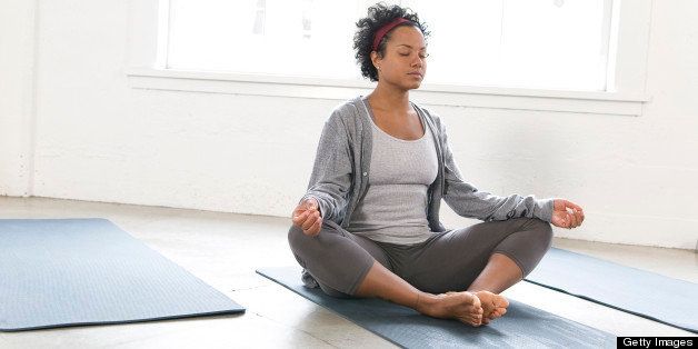 Woman meditating in a yoga studio, Vancouver, British Columbia