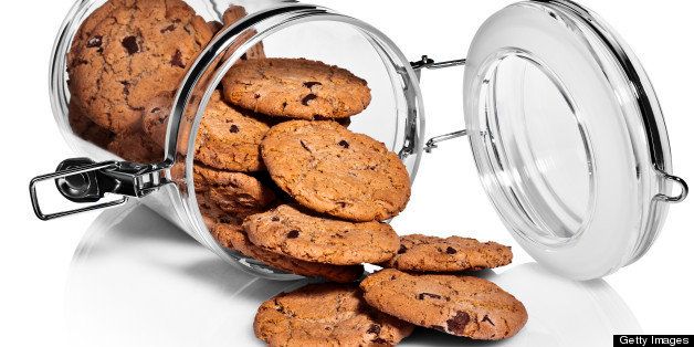 Clear cookie jar full of cookies, on white background, cut out