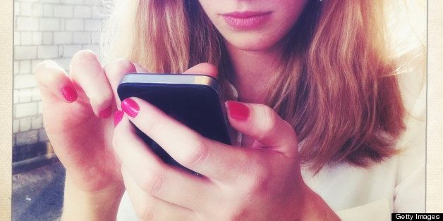 Portrait of young blond woman using smartphone.