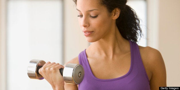 Young woman lifting dumbbells