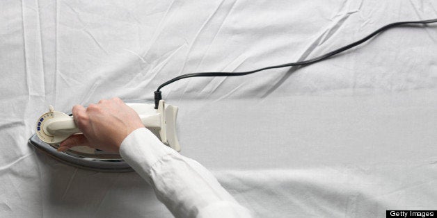 Woman ironing white cloth, close-up