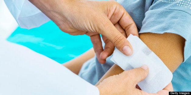 Doctor applying bandaid to little patient.