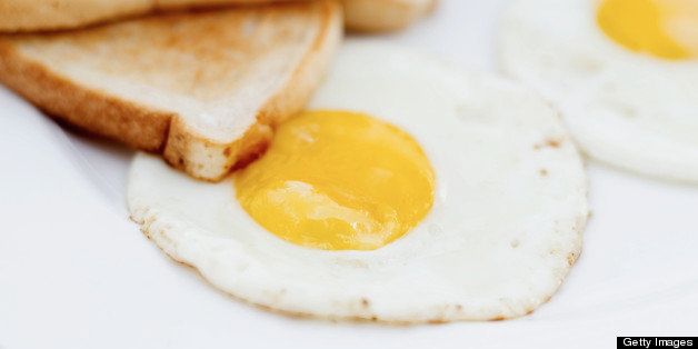 close-up of two fried eggs served with steak and toast