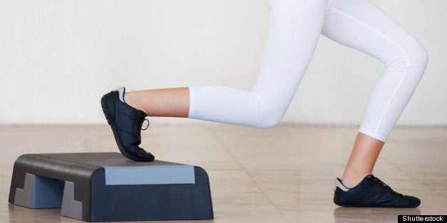 Side view of a young woman working out and doing lunges