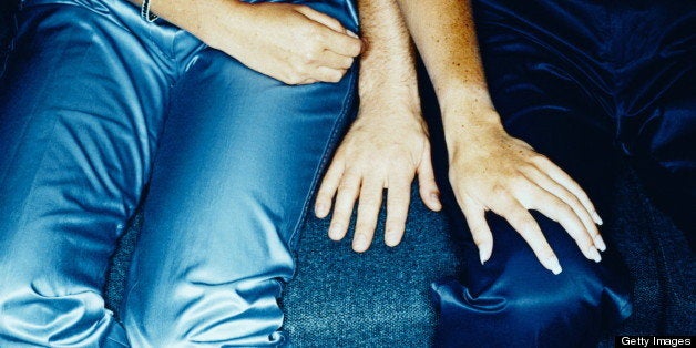 Couple sitting on couch, low section (cross-processed)
