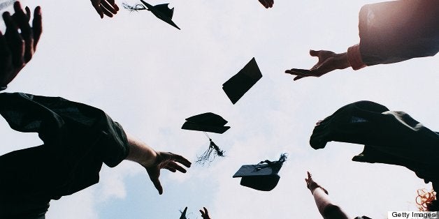 Five Students Throwing Their Mortar Boards in the Air at Graduation