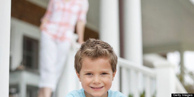 Boy sitting on porch, smiling