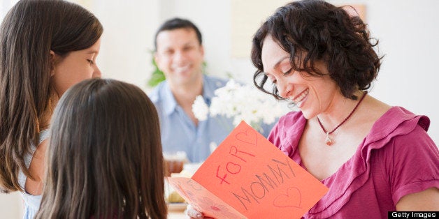 Daughters giving mother Mother's Day card