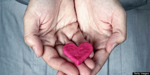 Woman holding the cracked pink heart in her hands. Saving love concept. Giving Heart.