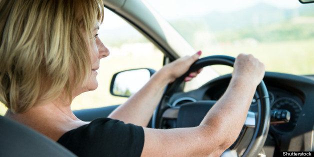 Lifestyle photo of attractive mature woman driving car