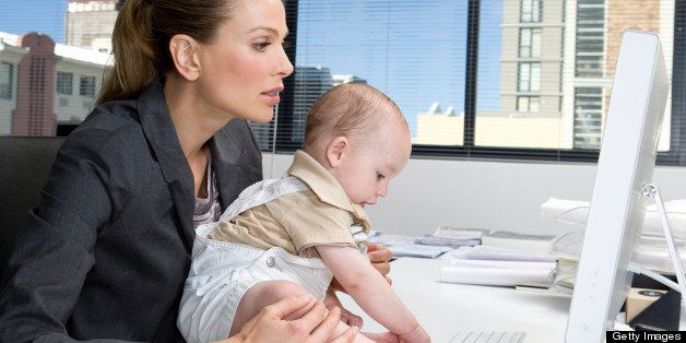 Baby using computer on desk of a businesswoman