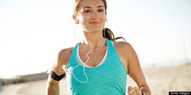 A beautiful athletic woman running along a footpath at a beach