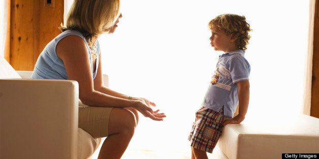 Mother discussing serious issue with child as if disciplining his behovior or teaching him a lesson