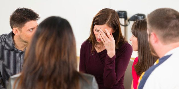 A woman sharing her emotions in a support group.