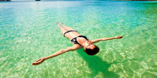 Young woman floating and relaxing backstroke in tropical water of Caribbean, St. Thomas U.S. Virgin Islands.