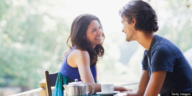 Smiling couple having tea outdoors