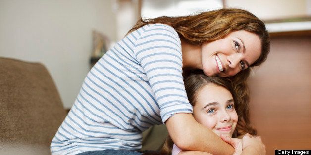 Mother and daughter hugging indoors