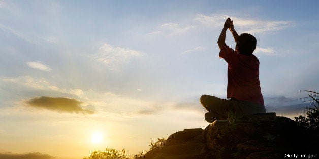 Man with yoga sitting pose in silhouette in outdoor.