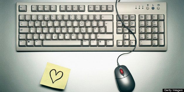 Computer keyboard with enlarged key L,O,V, E, a mouse, and adhesive note