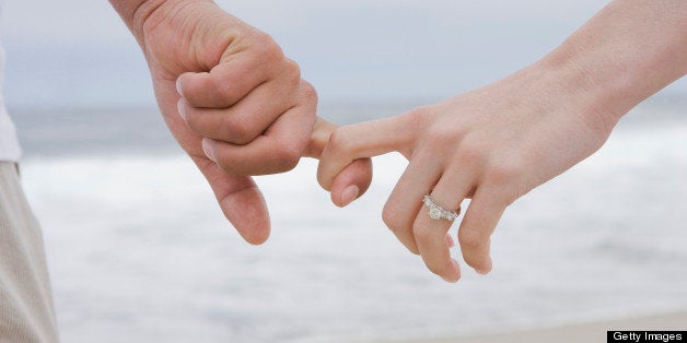 Hispanic couple holding hands on beach