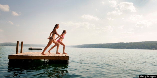 Two Girls Jumping Of Floating Dock