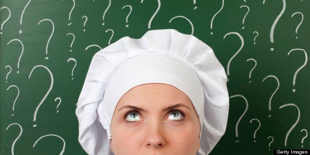 female chef thinking in front of question marks written blackboard