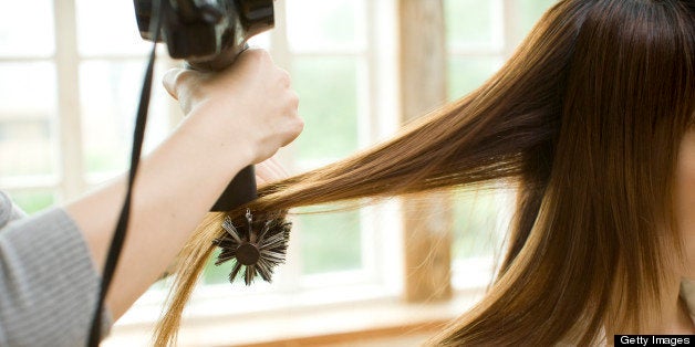 Woman's hair is combed. 