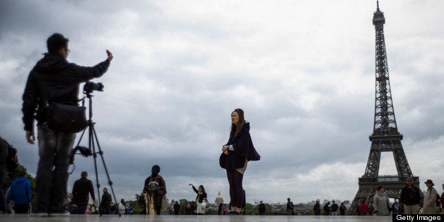 Tourists take picture of the Eiffel Tower, on Trocadero Square, on May 14, 2013 in Paris. Paris's image, already tarnished by alarm over recent tourist muggings, has taken a further bashing after violence during a trophy parade to mark Paris Saint-Germain's first French League win in 19 years. The shock violence occurred late Monday after up to 15,000 PSG fans, who had thronged the esplanade at Trocadero by the iconic Eiffel Tower to mark the victory, turned unruly and attacked tourists and others in the heart of the city. AFP PHOTO / FRED DUFOUR (Photo credit should read FRED DUFOUR/AFP/Getty Images)