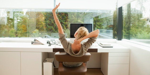 Young woman stretching at desk of office at home