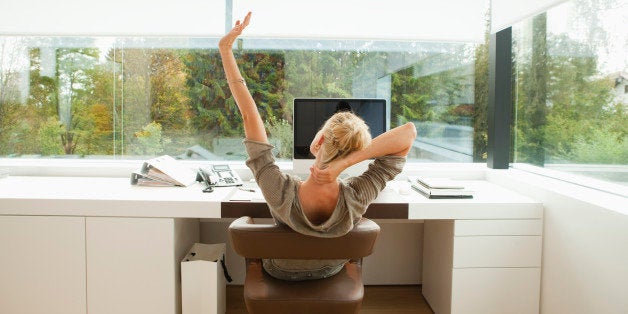 Young woman stretching at desk of office at home