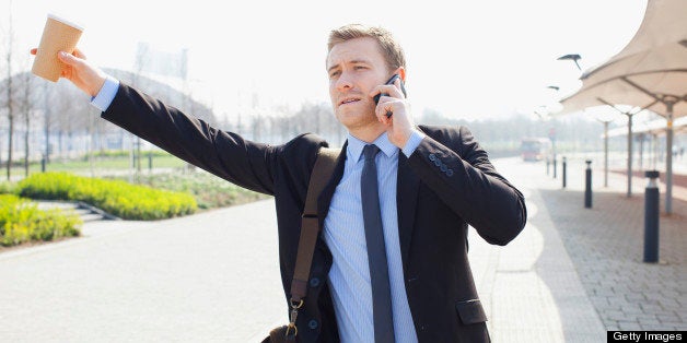 Businessman hailing taxi on city street