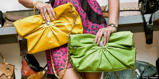 lady choosing between two colorful clutch bags