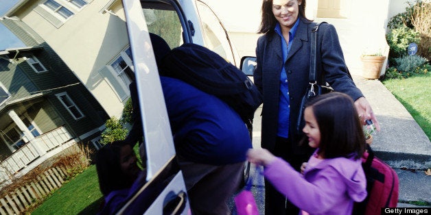Mother helping son and daughter (6-8) get into mini van
