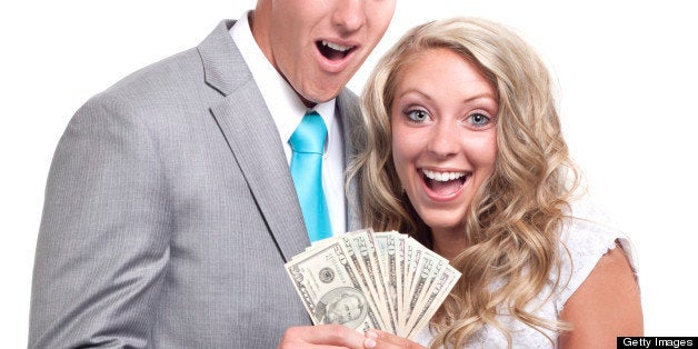 Beautiful wedding couple on white background holding 50 and 20 dollar bills (U.S. Currency)