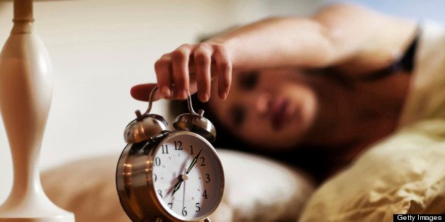 Woman Turning Off The Alarm Clock In The Morning