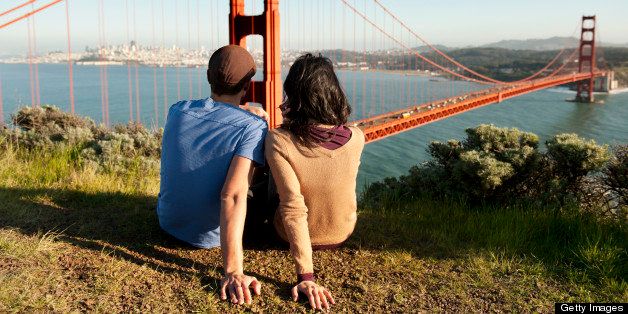 Couple Relaxing On Hill By Golden Gate Bridge