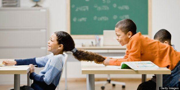 Mixed Race boy pulling girl's hair in school