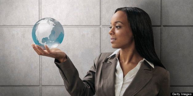 Mixed race businesswoman holding globe