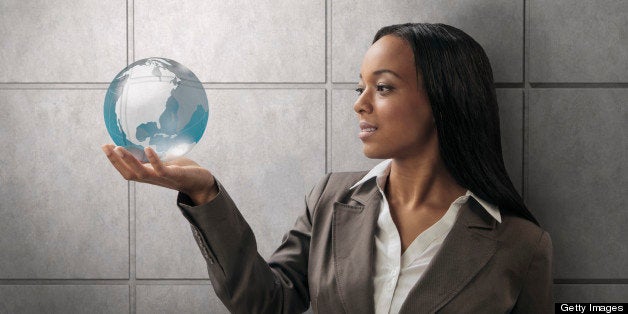 Mixed race businesswoman holding globe
