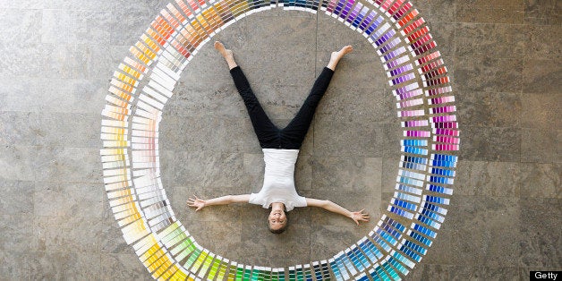 Businessman laying in paint swatches