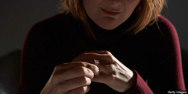 Woman adjusting wedding ring, mid section (focus on hands)