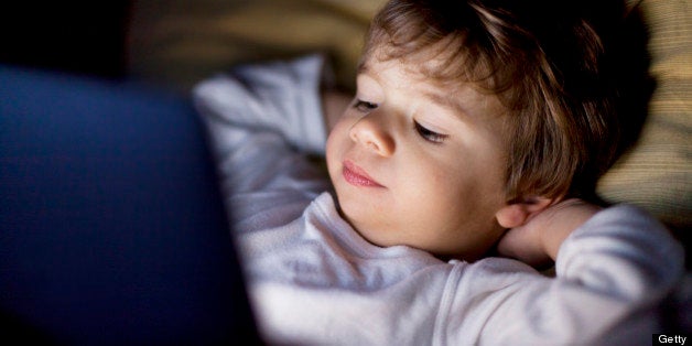 Small boy looking at a tablet in the dark