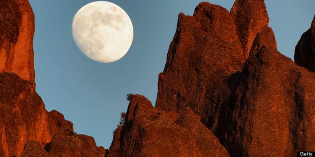 A nearly full moon rises over high peaks minutes before sunset at Pinnacles National Monument, Monterey County, California , USA.
