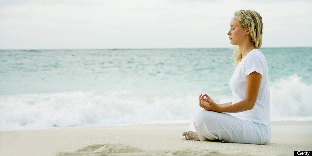 Woman meditating on tropical beach