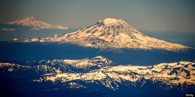 Mount St. Helens, backgrounded by Mount Rainier (L), is seen southeast of Seattle in the state of Washington, United States on June 10,2013. AFP PHOTO/JOE KLAMAR (Photo credit should read JOE KLAMAR/AFP/Getty Images)