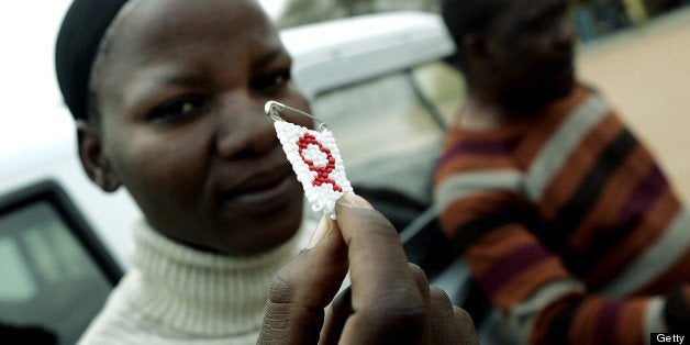 TO GO WITH AFP STORY IN FRENCH BY CHARLOTTE PLANTIVE Dineo Sumoke, member of the HIV+ support group in Gabane holds, 26 September 2007, the red ribbon as awareness symbol against HIV/AIDS in the backyard of a clinic in Gabane on the outskirt of Botswana capitol Gaborone. Botswana, a country whose president feared could be wiped off the map by AIDS, is living proof to other African countries that the pandemic should not be regarded as a death sentence. After embarking on a program to provide HIV sufferers with anti-retroviral drugs on a scale never before seen in Africa, only 8.5 percent of patients have died in the last five years, according to the southern African country's national AIDS coordinating agency (NACA). AFP PHOTO/GIANLUIGI GUERCIA (Photo credit should read GIANLUIGI GUERCIA/AFP/Getty Images)