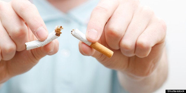 a hand crushing cigarettes