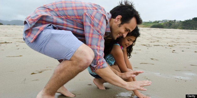 Loving Hispanic father with his daughter on the beach