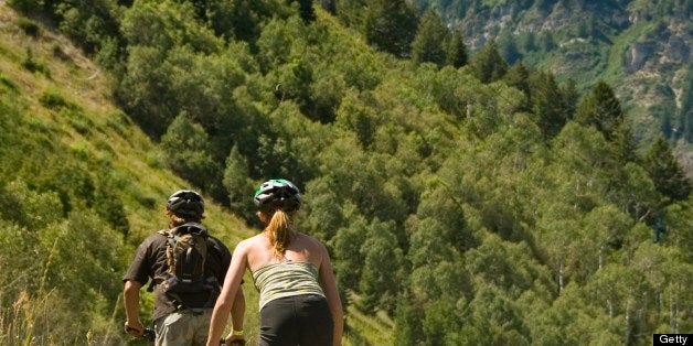 Couple riding bicycles on mountain trail